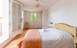 a bedroom with a white bed and a large window at Lagrange Vacances Domaine de Fayence in Fayence