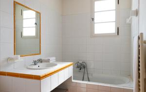 a bathroom with a sink and a tub and a mirror at Lagrange Vacances Domaine de Fayence in Fayence