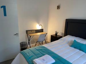um quarto com uma cama e uma secretária com um candeeiro em Casona Gorbea Hotel em Santiago