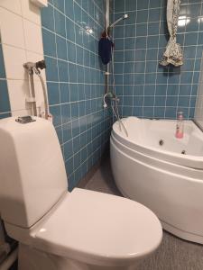 a bathroom with a toilet and a bath tub at Stockholm Guest apartment in Igelsta +11 photos
