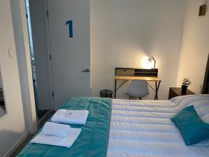 1 dormitorio con 1 cama con 2 toallas en Casona Gorbea Hotel, en Santiago