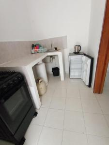 uma cozinha com uma mesa e piso em azulejo branco em Casa Maria Fernanda em Playa del Carmen
