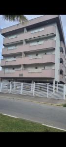 een groot appartementencomplex met een hek ervoor bij Cantinho do Boris III in Ubatuba