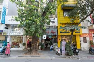 a woman walking down a street in front of buildings at Hanoi Retro 80S Homestay in Hanoi