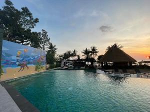 a swimming pool at a resort with a sunset at Kai Bae Beach Resort Koh Chang in Ko Chang