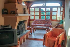 a living room with a couch and a tv at Doctors' House Mikros Prinos in Mikrós Prínos
