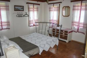 1 dormitorio con 1 cama en una habitación con ventanas en Doctors' House Upper, en Mikrós Prínos