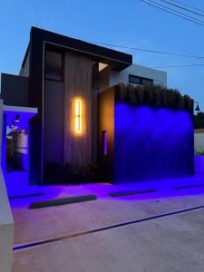 ein Haus mit lila Lichtern an der Seite in der Unterkunft Pasavento - Modern Tiny Suite in Aguadilla