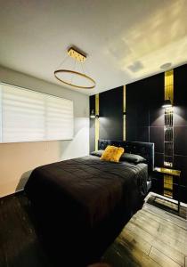 a bedroom with a black bed and a lamp at Pasavento - Modern Tiny Suite in Aguadilla