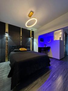 ein Schlafzimmer mit einem großen Bett mit violetter Beleuchtung in der Unterkunft Pasavento - Modern Tiny Suite in Aguadilla