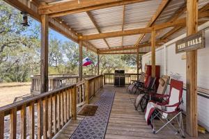 a wooden porch with rocking chairs on it at Stargazer Glamping Tent in Boerne