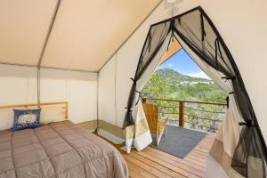 1 dormitorio con 1 cama y balcón en Twin Falls Luxury Glamping - Stargazer, en Boerne