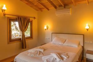 a bedroom with a bed with two towels on it at Secret Garden Hotel & Bungalows in Cıralı