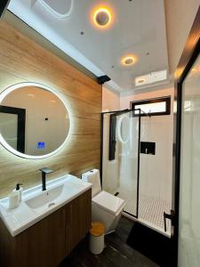a bathroom with a sink and a toilet and a mirror at Pasavento - Family Modern Suite in Aguadilla