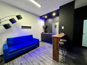 een woonkamer met een blauwe bank en een tafel bij Pasavento - Family Modern Suite in Aguadilla