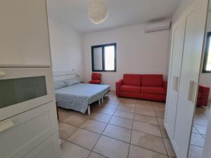 sala de estar con sofá rojo y cama en Accogliente villa con piscina en Caltagirone