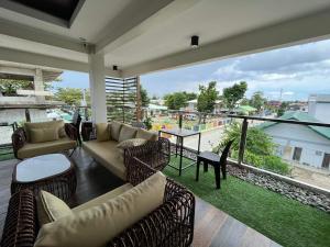 a living room with couches and tables and a large window at Baron & Pedra's Residence in General Luna
