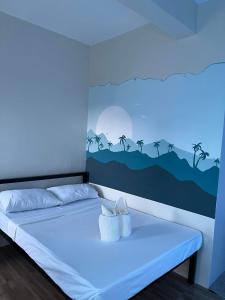 um quarto com uma cama com um quadro na parede em Baron & Pedra's Residence em General Luna