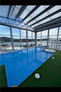 duży budynek z dużym błękitnym basenem w obiekcie Apartamento con vista al lago. w mieście Paipa