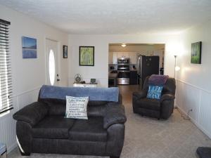 a living room with a couch and two chairs at Manist-easy - Lakefront With Dock And Kayaks! in Kalkaska