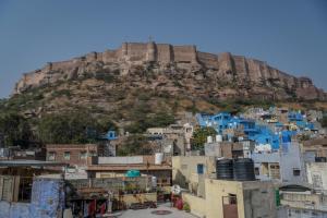 a view of the blue city with a mountain in the background at Pushp Guest House in Jodhpur