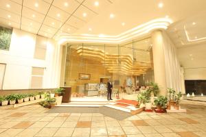 a man standing in the lobby of a building at Citadel Sarovar Portico Bengaluru in Bangalore