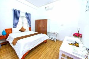 a bedroom with a large white bed and a desk at HOI AN Meditation-2bed near old town in Hoi An