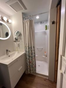 a white bathroom with a shower and a sink at Neat, compact, private room in a lovely Vancouver neighbourhood in Vancouver