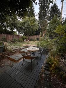 een patio met een tafel en stoelen in een tuin bij Neat, compact, private room in a lovely Vancouver neighbourhood in Vancouver