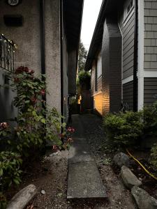 a small alley way to a house with flowers at Compact private room, private bathroom, laundry & free parking in a lovely Vancouver neighborhood in Vancouver +1 photo