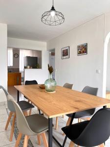 a dining room with a wooden table and chairs at L'Escale, appt partagé, shared apartment in Pointe-à-Pitre