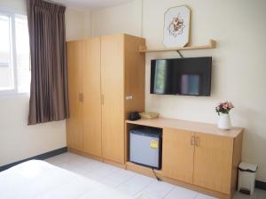 a room with a tv and a cabinet with a tv at NANA BEST INN HOTEL in Makkasan