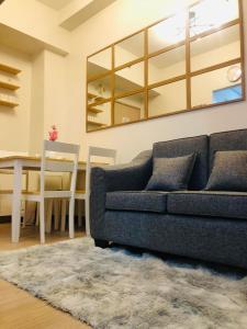 sala de estar con sofá y mesa en Osam Empire Suites 2BR Staycation at Trees Residences Condominium, en Manila