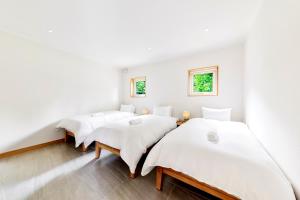 2 camas en una habitación con paredes blancas en Hakuba Views, en Hakuba