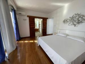 una camera con un grande letto bianco e un pavimento in legno di Villa luxueuse - Pointe aux Sables a Pointe aux Sable