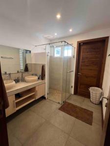 un bagno con due lavandini e una doccia in vetro di Villa luxueuse - Pointe aux Sables a Pointe aux Sable