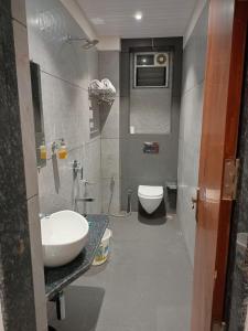 ein Bad mit einem Waschbecken und einem WC in der Unterkunft Sitara grand in Shirdi