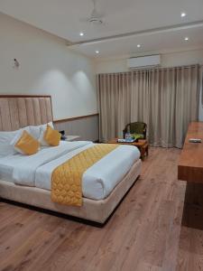 una camera d'albergo con un grande letto e una scrivania di Sitara grand a Shirdi
