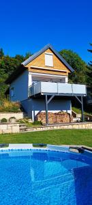 a house with a swimming pool in front of a house at Tiny House mit Panoramablick, Pool & Kamin! in Jena