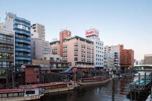 東京的住宿－貝爾蒙酒店，一座有建筑的城市和一条有船的河流