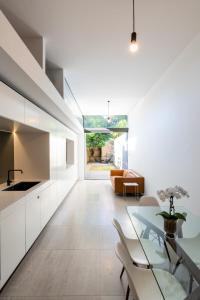 a kitchen with white cabinets and a glass table at Paddington House in Sydney