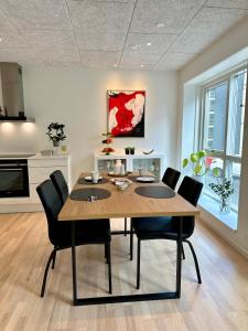 einen Esstisch mit schwarzen Stühlen in der Küche in der Unterkunft Luxury New Cozy and Quietly 95m2 in Tórshavn