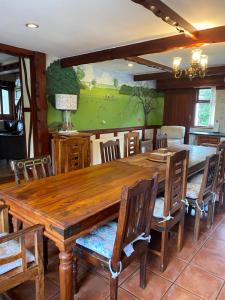 a dining room with a large wooden table and chairs at Rural Family Farmhouse with Countryside views in Southport