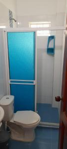 a bathroom with a toilet and a blue shower at Apartamento Don Mathias # 1 in Coveñas