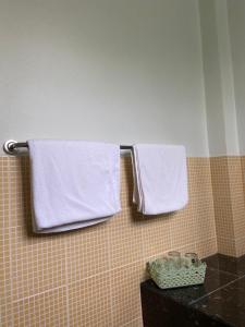 two towels are hanging on a towel rack in a bathroom at The Sandy House Khaolak in Khao Lak