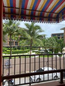 a view of a street with palm trees from a balcony at The Sandy House Khaolak in Khao Lak