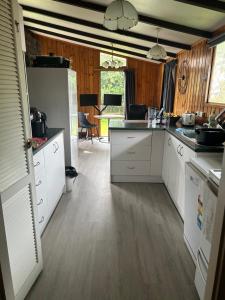  La cuisine est équipée de placards blancs et d'un réfrigérateur. dans l'établissement Sister’s place, à Auckland