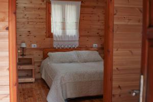 1 dormitorio con 1 cama en una habitación de madera en Farma Sotira, en Leskovik
