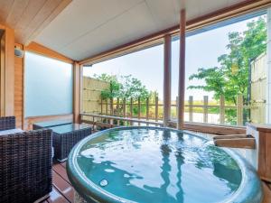 a hot tub on the deck of a house at Awara Onsen Matuya Sen Sen in Awara