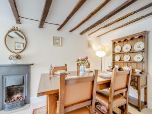 a dining room with a table and a fireplace at Lavender Cottage in Helmsley